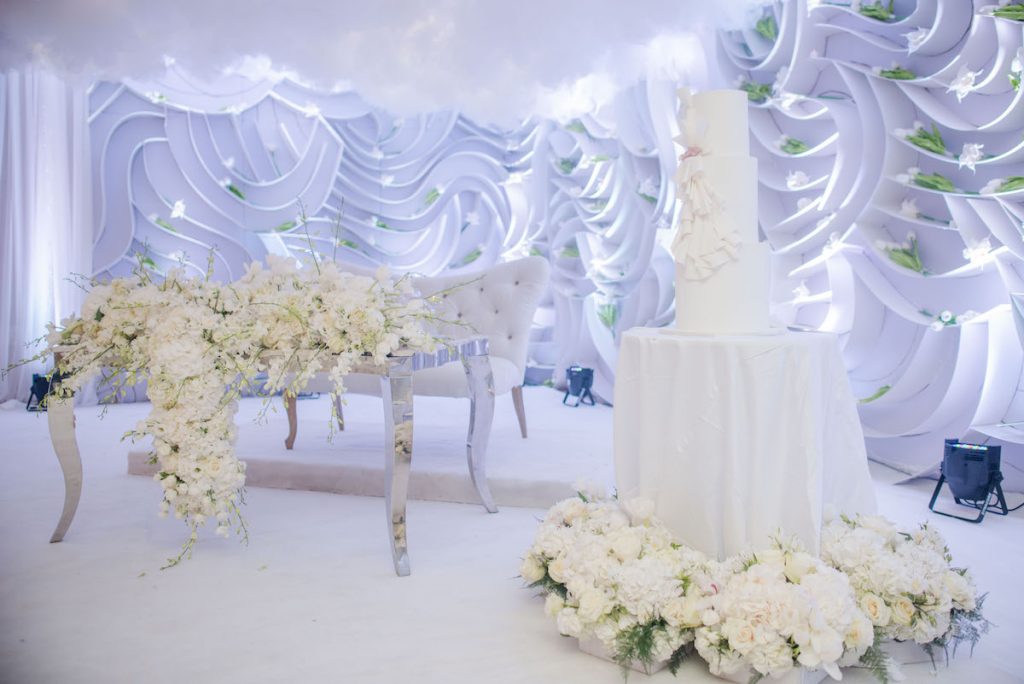 romantic wedding reception setup with clouds and lush flowers 