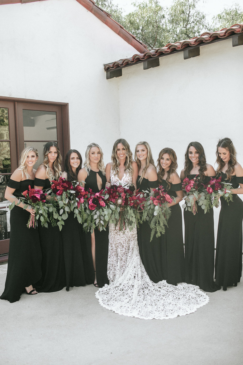 black bridesmaid dresses with red flowers and greenery bouquet