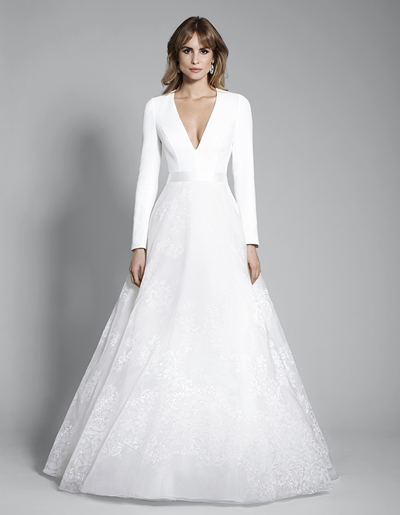 Long sleeve wedding dress with fitted bodice, flowing skirt and plunging neckline